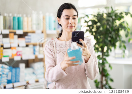 Young woman scanning qr code of mouthwash 125188489