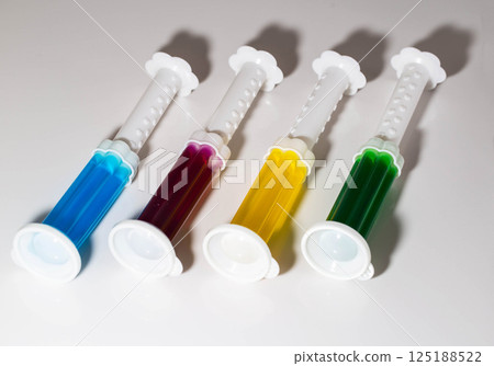 A set of multi-colored syringes with different scents on the toilet bowl in the toilet for cleaning and disinfection. Hygiene and antibacterial effect, close-up 125188522