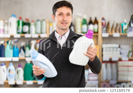 Man consumer with household chemical products for washing indoors 125188579