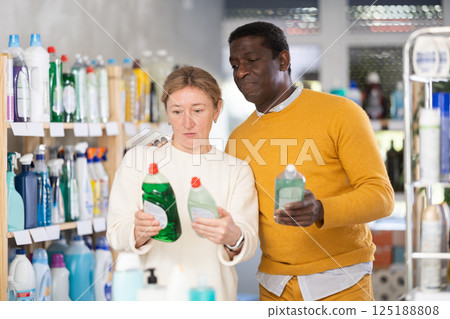 Couple man and woman choosing dishwashing detergent in store 125188808