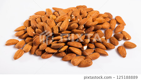 Close up of roasted almonds on white surface, no people 125188889