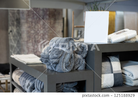 Home goods store, plaid compactly packed and wrapped with ribbon lies on shelf of showcase Home goods store, plaid compactly packed and wrapped with ribbon lies on shelf of showcase 125188929