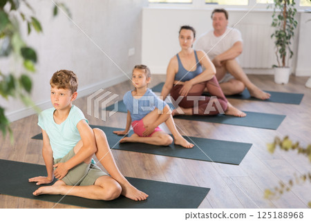 Family with two children doing yoga in studio 125188968