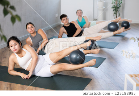 Young people doing softball pilates. Young people doing softball pilates. 125188983