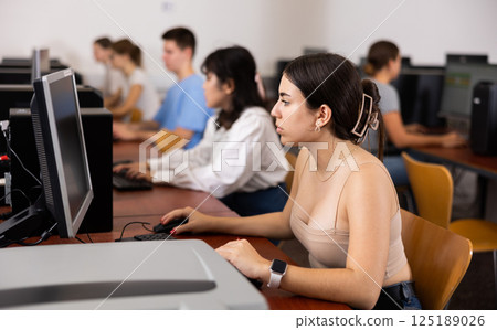 Teenage girl using computer during lesson Teenage girl using computer during lesson 125189026