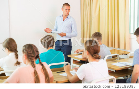 Teacher conducting lesson for teenage schoolchildren in classroom Teacher conducting lesson for teenage schoolchildren in classroom 125189383