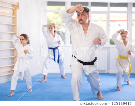 Family with children training karate techniques Family with children training karate techniques 125189415