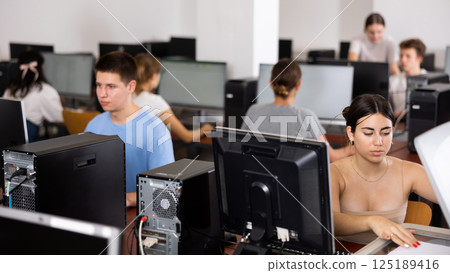 Concentrated Latin female student using PC and studying computer science in the classroom Concentrated Latin female student using PC and studying computer science in the classroom 125189416