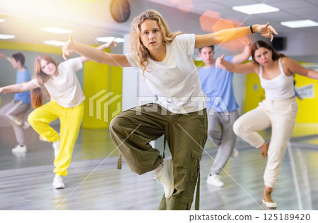 Expressive cool young dancers rehearsing their new dance during training together in studio Expressive cool young dancers rehearsing their new dance during training together in studio 125189420