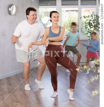 Parents with young daughter and schoolboy son are taught to move to boogie-woogie 125189437