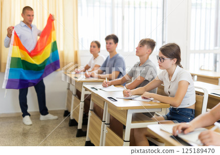 School teacher with flag explains to students what is LGBT 125189470