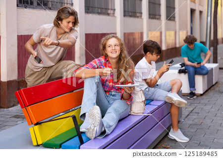 Guy and girl have fun chatting. Guy points his hand at someone Guy and girl have fun chatting. Guy points his hand at someone 125189485