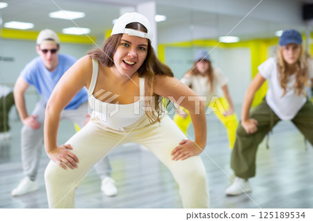 Boy and girls dancing synchronous group choreography in dance hall 125189534