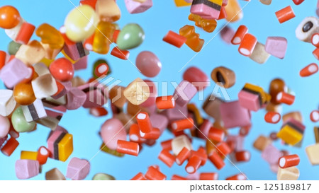 Freeze motion of flying various kind of candies. Colored abstract sweet background. 125189817