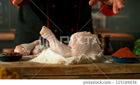 Freeze Motion of Falling Raw Chicken Leg into Flour . Closeup of Meat Preparation Freeze Motion of Falling Raw Chicken Leg into Flour . Closeup of Meat Preparation 125189836