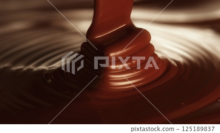 swirl of melted dark chocolate background, sweet liquid cocoa dessert 125189837