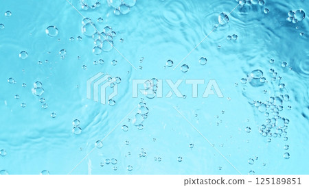 Transparent blue colored clear calm water surface texture with splashes and bubbles. Trendy abstract nature background. 125189851