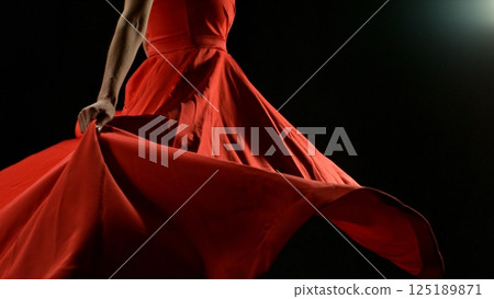 Closeup of Woman in red dress dancing with flying fabric, Fashion Model Girl Posing with waving cloth. 125189871