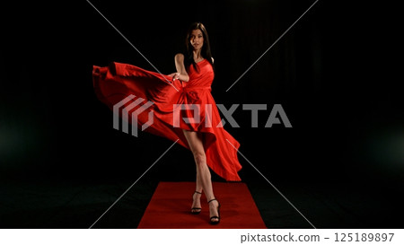 Woman in red dress dancing with flying fabric, Fashion Model Girl Posing with waving cloth Woman in red dress dancing with flying fabric, Fashion Model Girl Posing with waving cloth 125189897