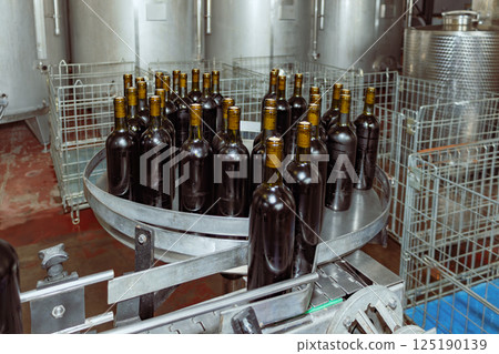 Wine bottles moving on conveyor belt in modern winery 125190139