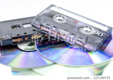 A nostalgic collection of audio cassette tapes and compact discs. 125190735
