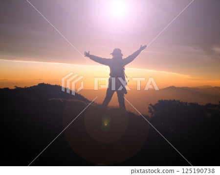 登山者在山頂上崇拜太陽 125190738