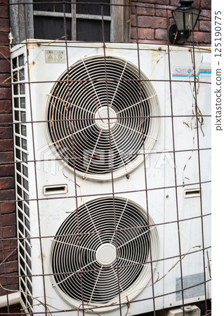 Outdoor unit installed on the wall of a building 125190775