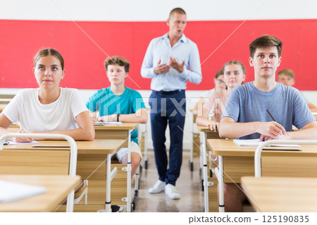 Young students sitting at desks in classroom Young students sitting at desks in classroom 125190835