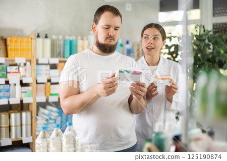 Man choosing pills with help from pharmacist 125190874