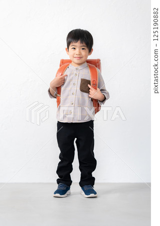 5-year-old boy carrying a school bag 125190882