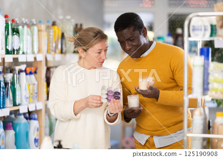 Couple man and woman choosing scented candles in store Couple man and woman choosing scented candles in store 125190908