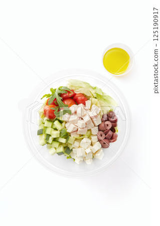 Portion of healthy greek salad bowl isolated on white background Portion of healthy greek salad bowl isolated on white background 125190917