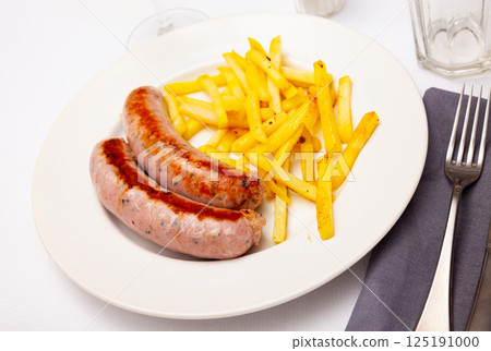 Close up of tasty fried pork sausages with french fries 125191000