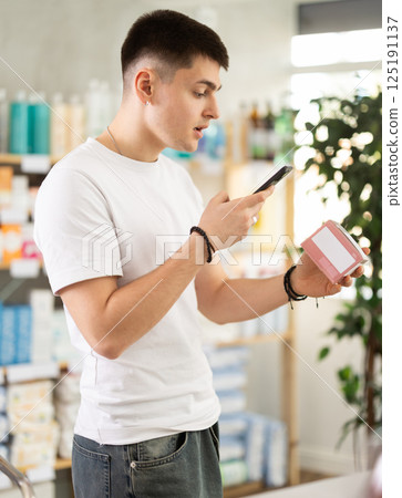 guy scans a package of pills on his phone 125191137