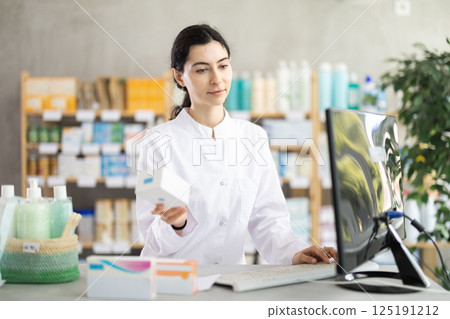 Female pharmacist searches for information about medicines on Internet Female pharmacist searches for information about medicines on Internet 125191212