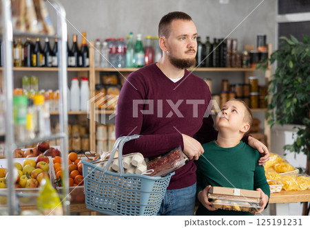 Dad and son are choosing products in supermarket Dad and son are choosing products in supermarket 125191231