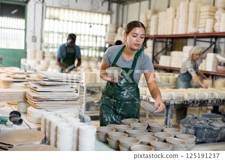 Female potter arrange pottery plate at factory ceramic 125191237