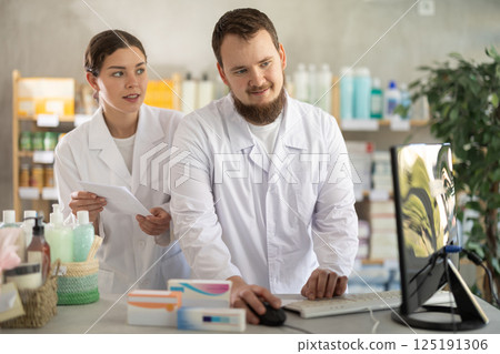 Two pharmacists working at a computer 125191306