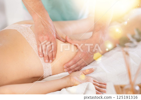 Woman lies and enjoys during anti-cellulite massage in buttocks Woman lies and enjoys during anti-cellulite massage in buttocks 125191316