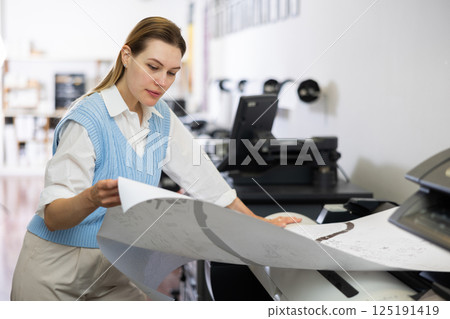 Woman working in printing office, using printer Woman working in printing office, using printer 125191419