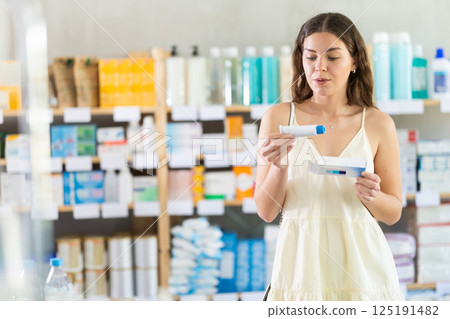 Girl buys gel for burns at pharmacy Girl buys gel for burns at pharmacy 125191482