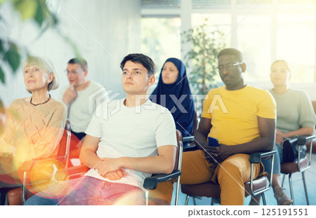 Guy teenager listens to lecture while sitting on chair Guy teenager listens to lecture while sitting on chair 125191551