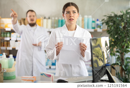 Confused girl pharmacist employee during argument with boss 125191564
