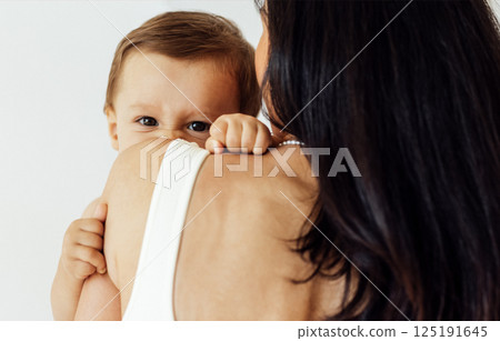 A young woman holds her beautiful baby. Charming mom with a sweet cute toddler A young woman holds her beautiful baby. Charming mom with a sweet cute toddler 125191645