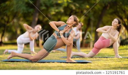 Group of young women doing yoga in park Group of young women doing yoga in park 125191761