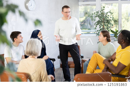 Smiling man conducting informal work meeting with colleagues 125191863
