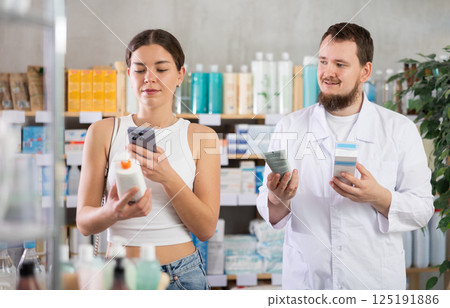 Woman scans QR code on skin creamp label. Male pharmacist offers to choose skin creamp 125191886