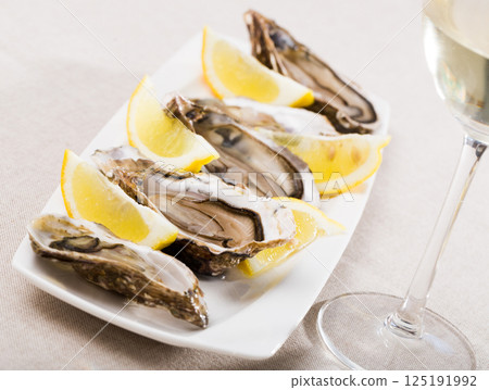 Opened raw oysters with lemon 125191992