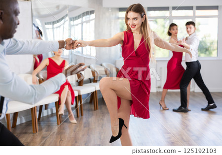 Woman dances incendiary boogie woogie with African man partner during choreography lesson Woman dances incendiary boogie woogie with African man partner during choreography lesson 125192103
