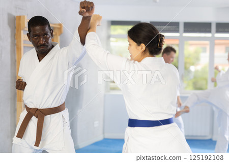 Multinational pupils train to perform defensive karate installations and attacking combat techniques 125192108